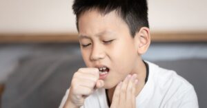 Bambino che tossisce per le placche alla gola