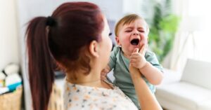 Alt: bronchiolite nei neonati, madre che cura bambino che piange