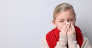 sangue dal naso, bambina che si soffia il naso per raffreddore